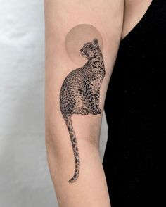 a woman's arm with a black and white tattoo of a cat on it