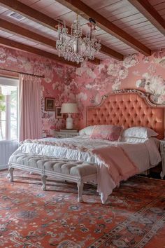 a bedroom decorated in pink and white with a chandelier hanging from the ceiling