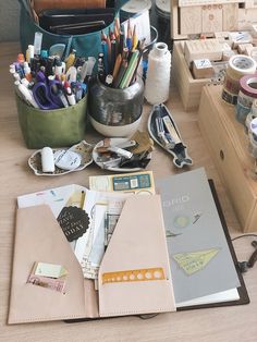 an open book sitting on top of a wooden table next to craft supplies and scissors