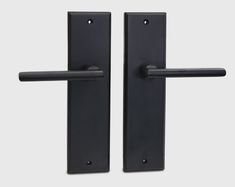 two black door handles with one handle open and the other closed