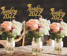 three mason jars filled with flowers sitting on top of a table next to each other