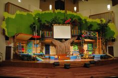 the stage is set up for a children's play show with trees and slides