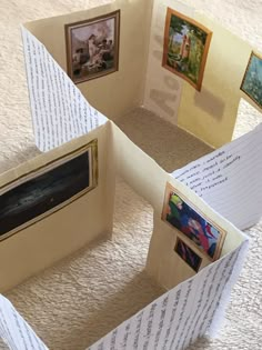 an open book with pictures on it sitting on top of a carpeted floor next to a wall