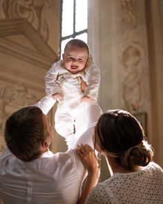 a woman holding a baby up in the air