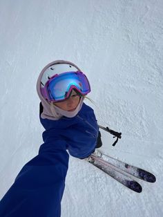 a person wearing skis and goggles standing in the snow