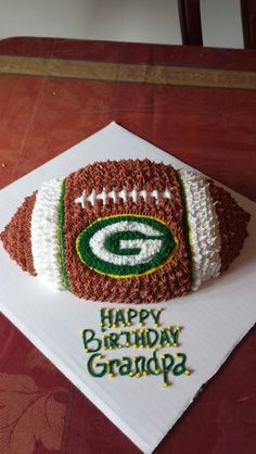 a birthday cake made to look like a football on top of a napkin with the name happy birthday grandpa