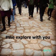 a group of people walking down a cobblestone road with the words we explore with you