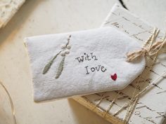 two pieces of cloth with embroidered words on them sitting next to some string and scissors