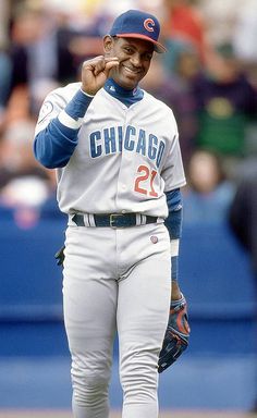 a baseball player standing on the field with his hand to his ear and wearing a catchers mitt