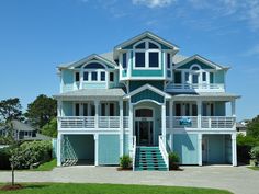 a large blue and white house on the beach