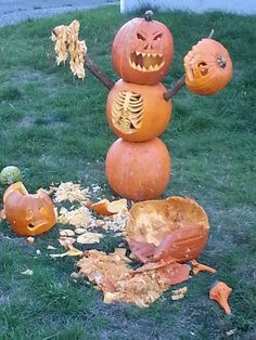 a group of pumpkins that are sitting in the grass with faces carved into them