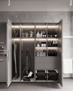 an open closet with many items on the shelves and in it is a vacuum cleaner