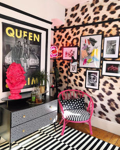 a pink chair sitting in front of a black and white rug