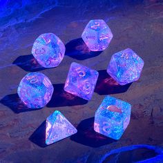 glowing dice set with numbers and symbols displayed on dark surface in blue light, top view