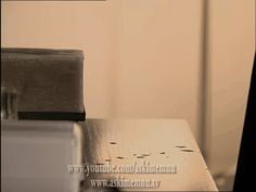 a close up of a metal table with a clock in the back ground and a white wall behind it