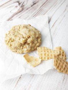 a cookie and waffles sitting on top of a piece of wax paper next to each other