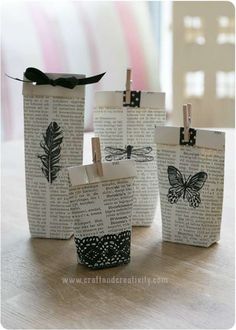 three small bags with clothes pins attached to them on a table next to some books