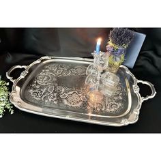 an ornate silver tray with two candles on it