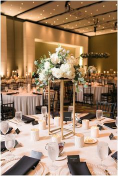 an elegant centerpiece with white flowers and greenery