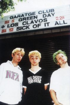 three young men are standing in front of a movie theater marquee with the words garage club los clavos and sick of it all