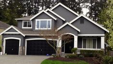 a large house with two car garages in front of it and lots of trees