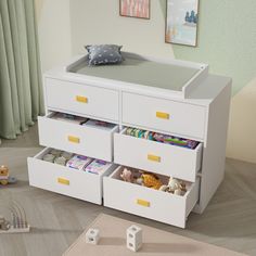 a baby's bed with drawers and toys in the bottom drawer on the floor