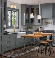 a kitchen with gray cabinets and an island in front of the countertop is shown