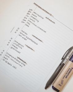 a pen sitting on top of a piece of paper next to some writing utensils