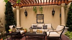 an outdoor living area with couches, tables and potted plants on the patio