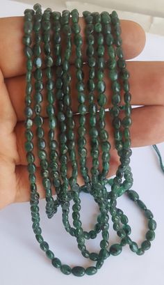 green beads are being held by someone's hand