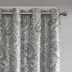 the curtain is hanging in front of the window with an intricate pattern on it,