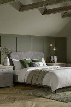 a bedroom with a bed, nightstands and two lamps on either side of the bed