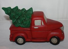 a red toy truck with a christmas tree on the back