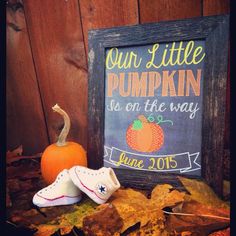 there is a sign that says our little pumpkin is on the way and some shoes are next to it