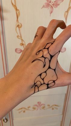 a person's hand with a tattoo design on the middle of their left palm