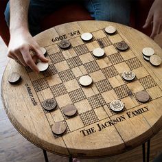 a person playing a game of chess on a wooden table with some coins around it