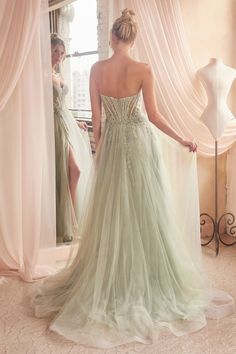 a woman standing in front of a mirror wearing a dress with sheer tulle and beading