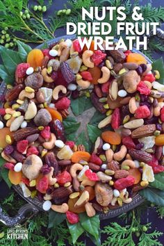 nuts and dried fruit wreath on a platter surrounded by greenery with text overlay