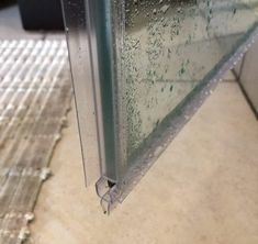 a window with water droplets on it sitting in the middle of a tiled flooring area