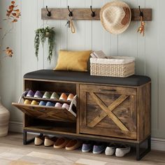 a wooden bench with shoes on it next to a wall mounted coat rack and hat rack