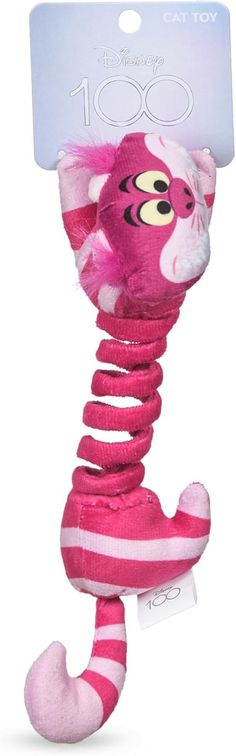 a pink stuffed animal with a tag on it's neck and legs that are curled up in the shape of a cat