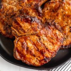 grilled pork chops on a black plate