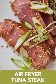 an air fryer tuna steak with sesame seeds and green onion garnishes