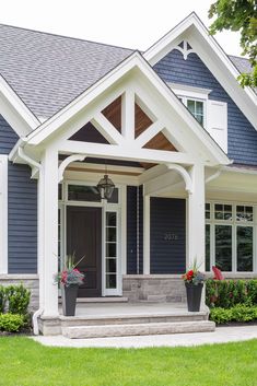 a house with blue siding and white trim on the front door is shown in this image