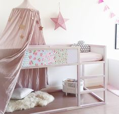 a child's bedroom with a pink canopy bed and stars on the wall above it