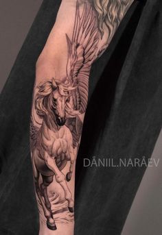 a man with a tattoo on his arm has a horse and bird design on it