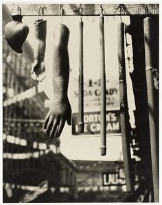 an old black and white photo of a hand hanging from a bar with other items