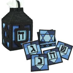 four pieces of blue and black cross stitched napkin holder with tissue dispenser