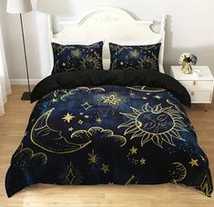 a bed with black and gold comforter covers on it in a white room next to a night sky