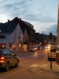 cars are driving down the street at dusk